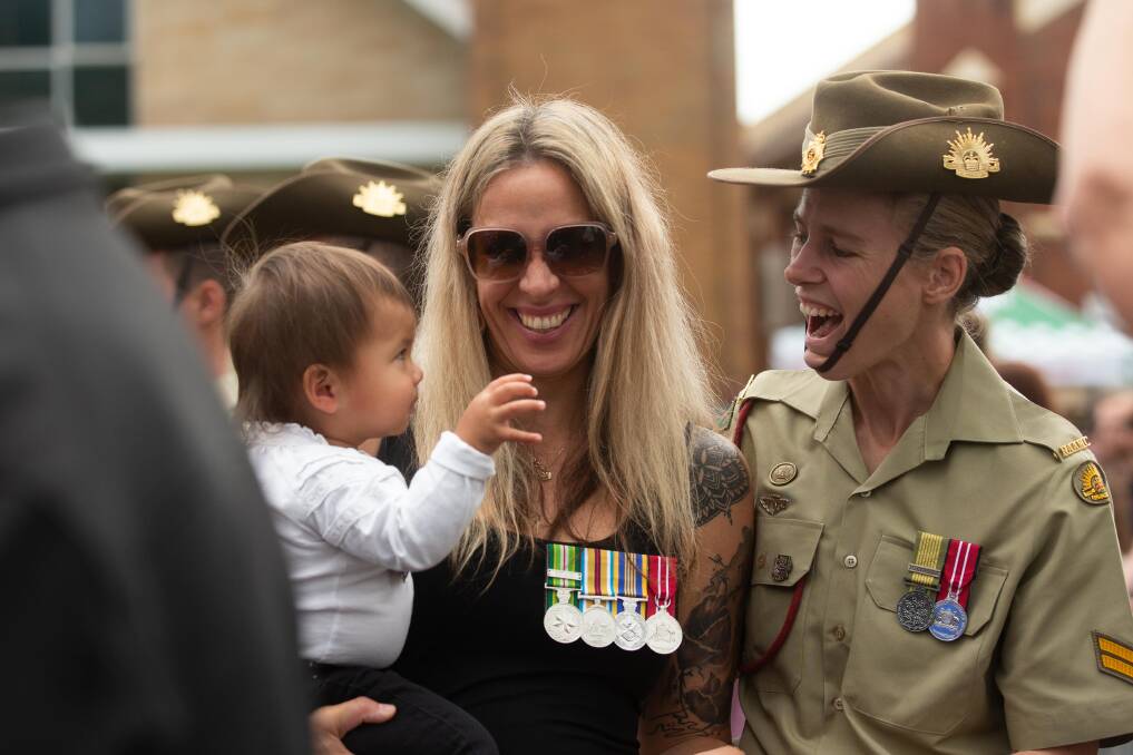 Alana Hayward holding baby Stevie Gentzen, and Singleton School of Infantry's corporal Taylah Gentzen at East Maitland's Anzac Day service. Pictures by Jonathan Carroll